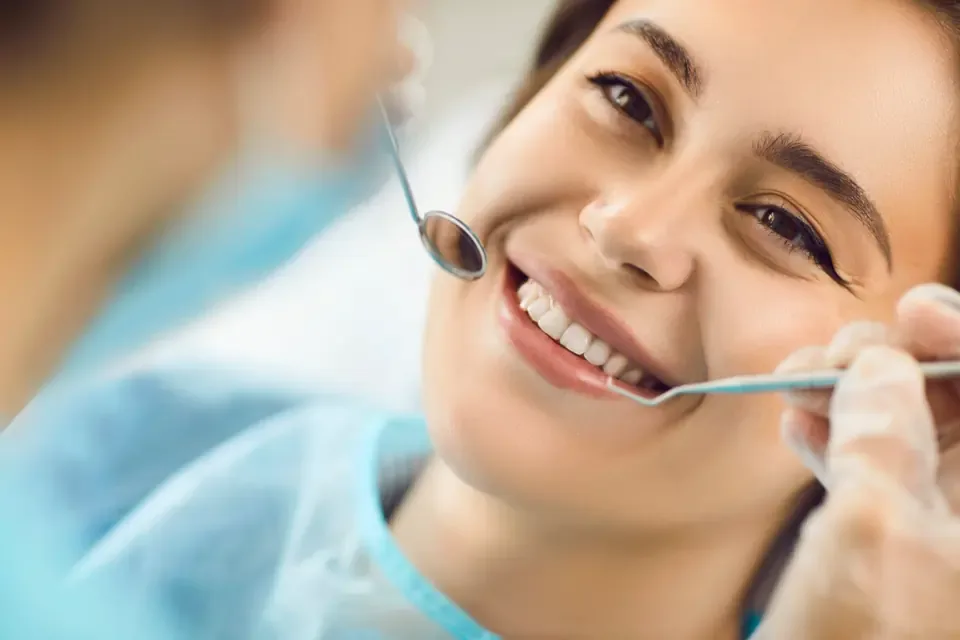 Smiling patient during a dental check with a mouth mirror