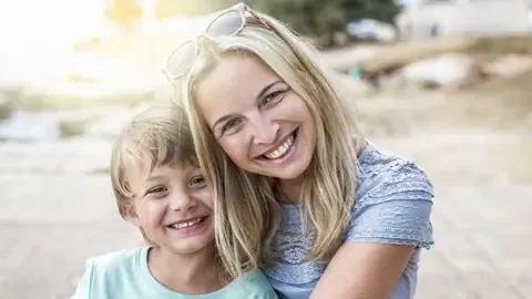 Mother and young son smiling together outdoors